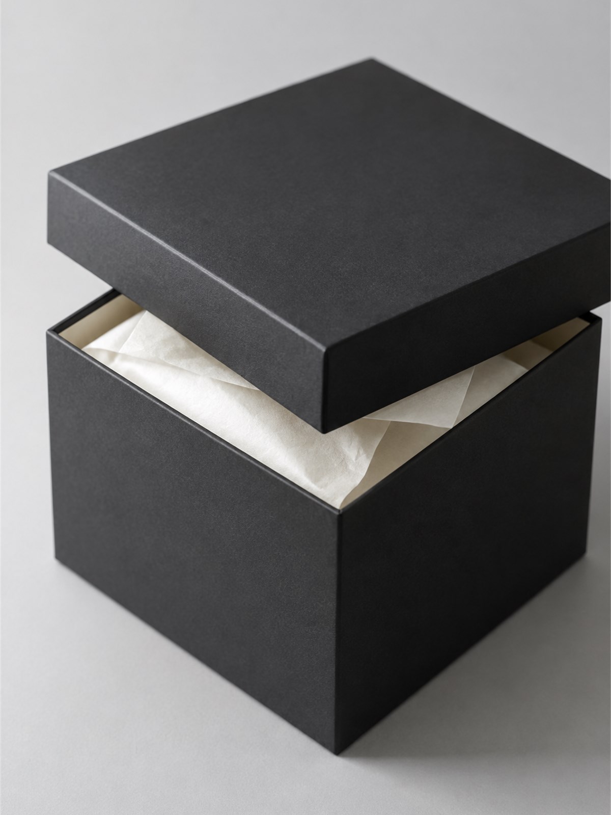Deep green rigid box with a magnetic lid and copper foil mark, photographed on a paper workbench